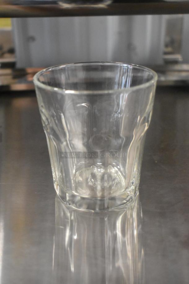 Set of 16 brand new beverage glasses, scratch and dent condition, clear glass, durable design, ideal for everyday use.