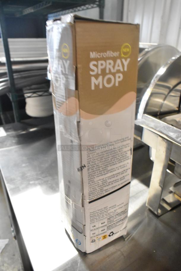 Box of Microfiber Spray Mop, brand new, labeled "scratch and dent," visible text and logos, minor packaging wear.