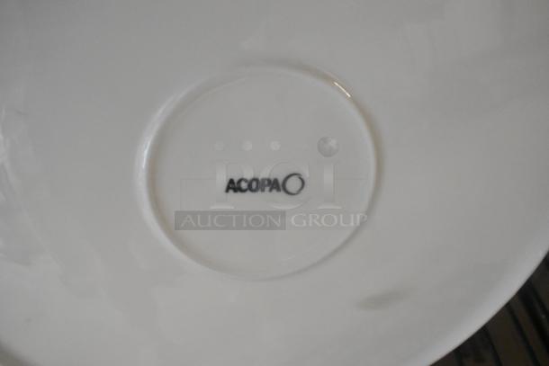 12 new Acopa white plates, slight scratch and dent. Durable ceramic, sleek design. Acopa logo visible on underside.