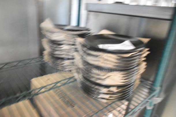 Blurry image of stacked Acopa black plates, labeled "Scratch and Dent." Auction includes 36 new plates.