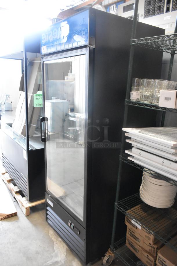 Brand new Avantco 178GDC24FHCB 31" black merchandiser freezer with swing glass door, LED lighting; minor scratches visible.