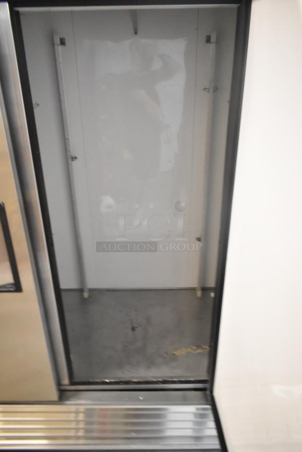 True T-72 stainless steel commercial 3-door reach-in cooler, 115V, 1-phase. Interior view, some wear visible on the floor.