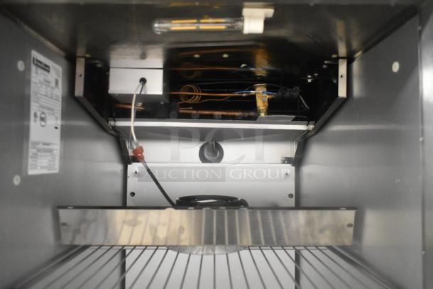Traulsen ALT132DUT-HHS stainless steel reach-in freezer interior view, showcasing wiring and coils. Model label visible.