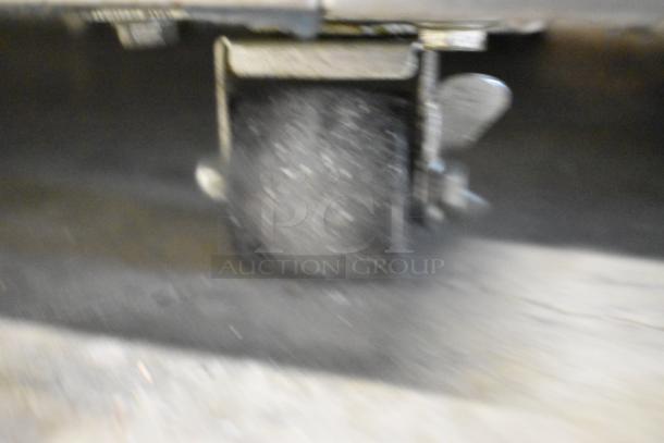 Blurred image of a commercial caster on the Traulsen ALT132DUT-HHS stainless steel freezer.