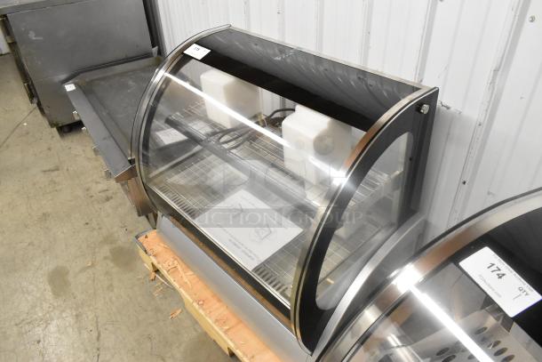 Brand new Vollrath HDE8136 36" countertop curved glass heated display cabinet, 120 volts, 1 phase, tags visible.
