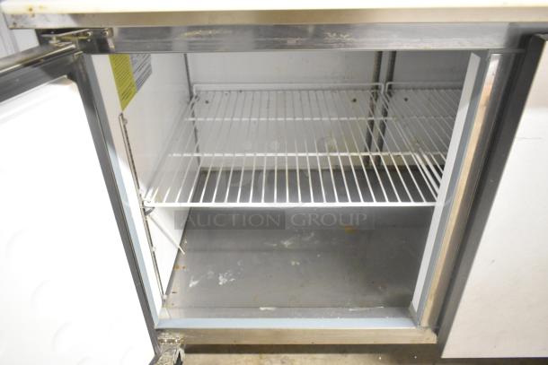 Yukon YPP71 stainless steel commercial pizza prep table, open door showing wire shelves, on commercial casters, 115 volts.