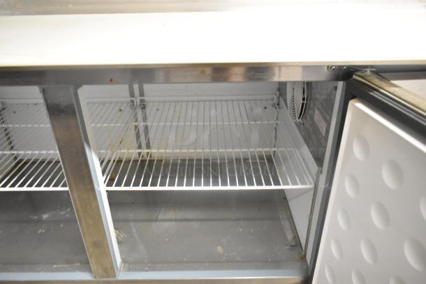 Yukon YPP71 stainless steel pizza prep table, commercial-grade, on casters, 115V, 1 phase, internal shelving shown, good condition.