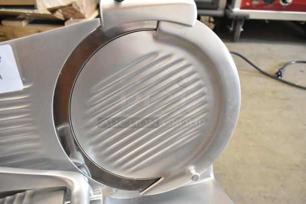 Brand new Globe Chefmate stainless steel commercial meat slicer, 115 volts, with blade sharpener, minor scratches visible.