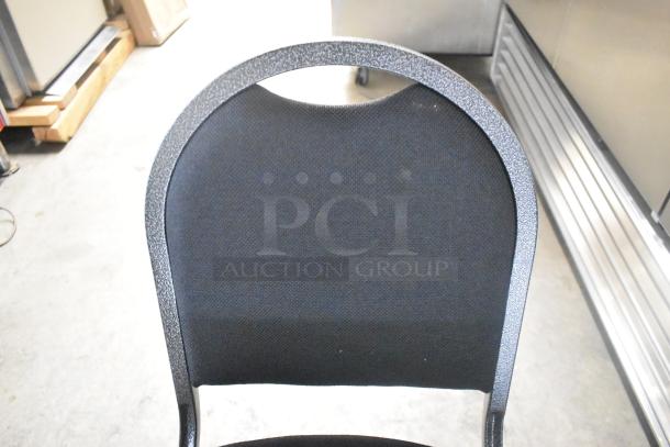 Brand new black metal stackable banquet chair with a scratch and dent. Durable fabric seat, sturdy construction. Auction doubles bid.
