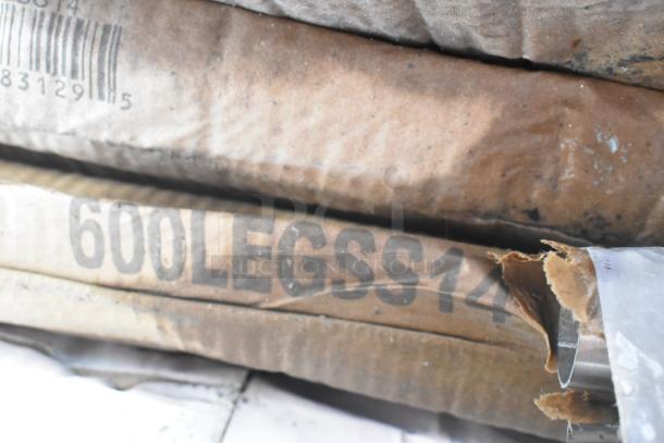 Stacked boxes containing Regency 600LEGSS14 stainless steel legs, visible labeling, new condition.