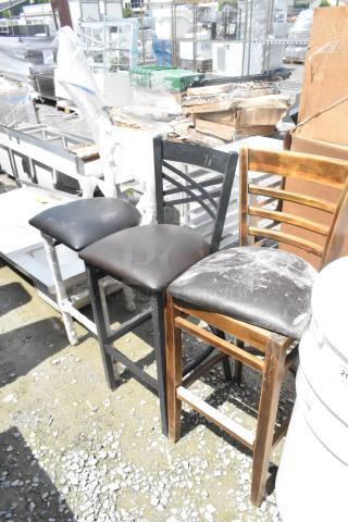 Three bar height chairs, brand new with visible scratches and dents, featuring various designs and finishes.