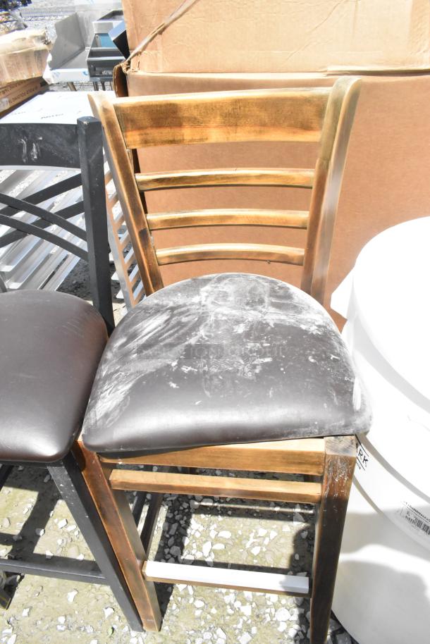 Bar height chair with a wooden ladder back and black seat, slight scratches. Offers scratch-and-dent value.
