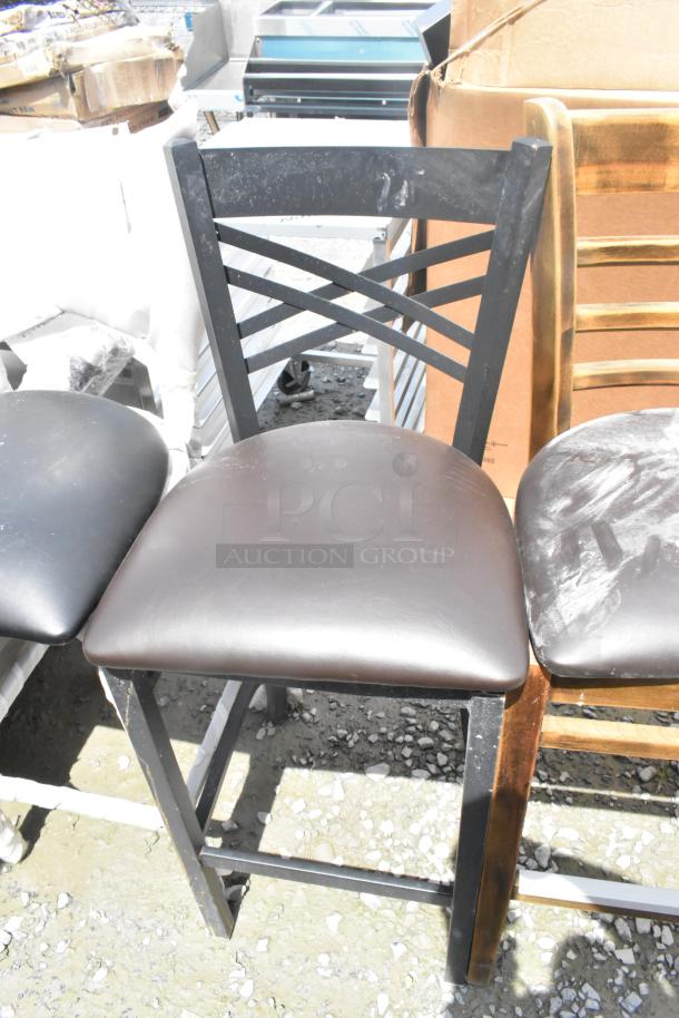 Three bar-height chairs, scratch and dent condition, black metal frames, dark cushioned seats, stack of two shown.