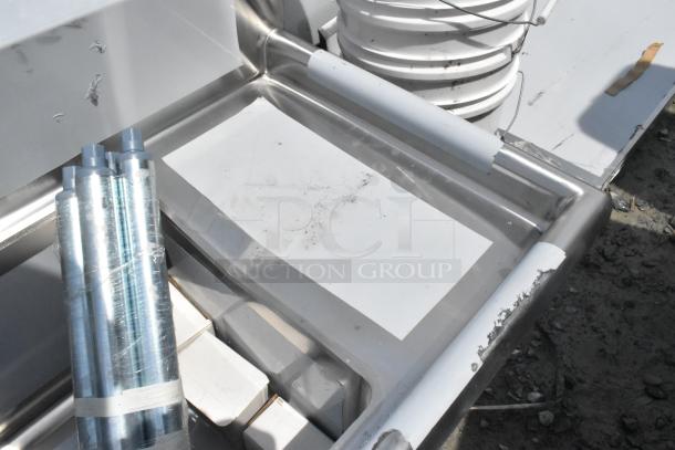 Regency 600S31416212 stainless steel 3 bay sink with dual drain boards, scratch-dented, no legs, visible surface marks.