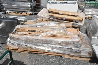 Six new scratch and dent items on a pallet, including stainless steel work table, shelving unit, canopy tent, umbrella frame.