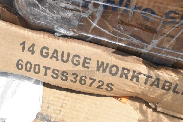 Box label showing "14 Gauge Work Table" and model "600TSS3672S." Packaging appears slightly damaged.