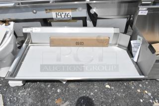 Brand new Regency 600CDT60L 16 Gauge 5' clean dish table with left drainboard, visible tape, slight scratch, suggests handling marks.