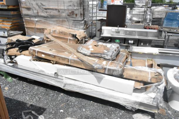 Packaged stainless steel tables labeled as "scratch and dent," 15 new items, wrapped with protective material.