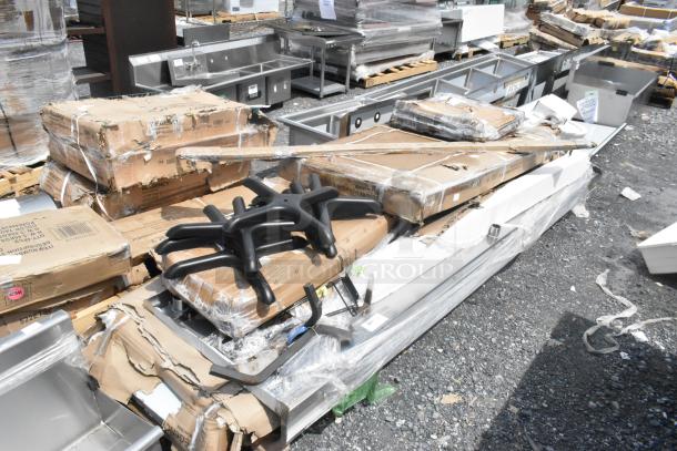 15 brand new scratch and dent items including boxed Regency stainless steel tables on pallets, various other components visible.