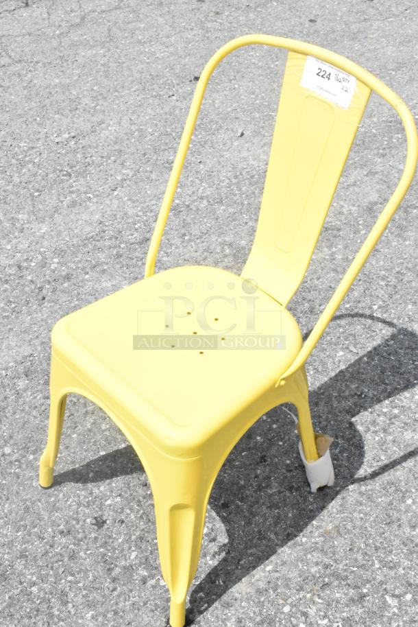 Yellow metal Tolix style chair, scratch and dent condition, features a minimalist design with curved backrest and perforated seat, brand new.