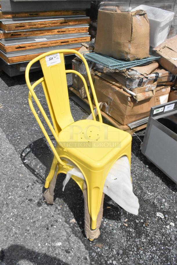Yellow metal Tolix style chair, new with minor scratches. Label reads "224." Industrial design, scratch and dent sale.