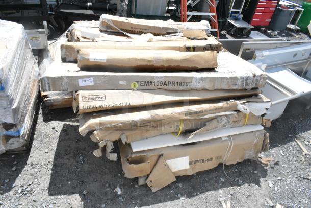 Cardboard boxes containing scratch and dent items including a Steelton Utility Wire Shelf Kit and various components.