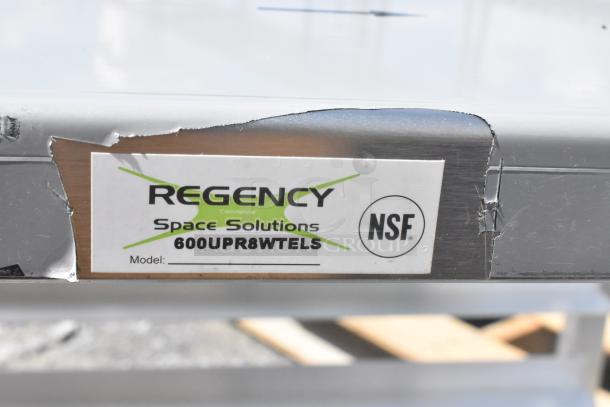 BRAND NEW Regency 600UPR8WTELS aluminum sheet pan rack with stainless top, visible dents on side. NSF certified.