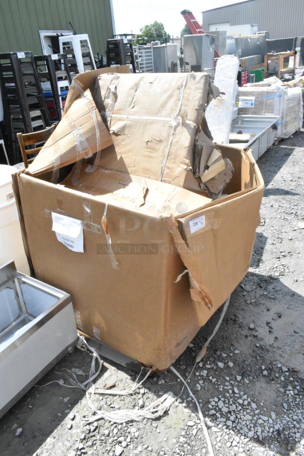 Damaged cardboard box with new stainless tables and metal shelves labeled "Scratch and Dent," outside. Includes various items.