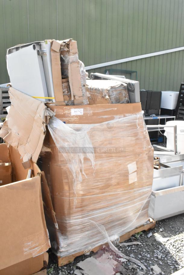 Pallet of 20 new scratch-and-dent items, including a stainless steel table and platform truck, wrapped in packaging.