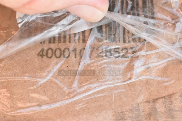 Close-up of a hand peeling plastic to reveal a barcode and numbers on cardboard packaging, indicating new scratch and dent items.