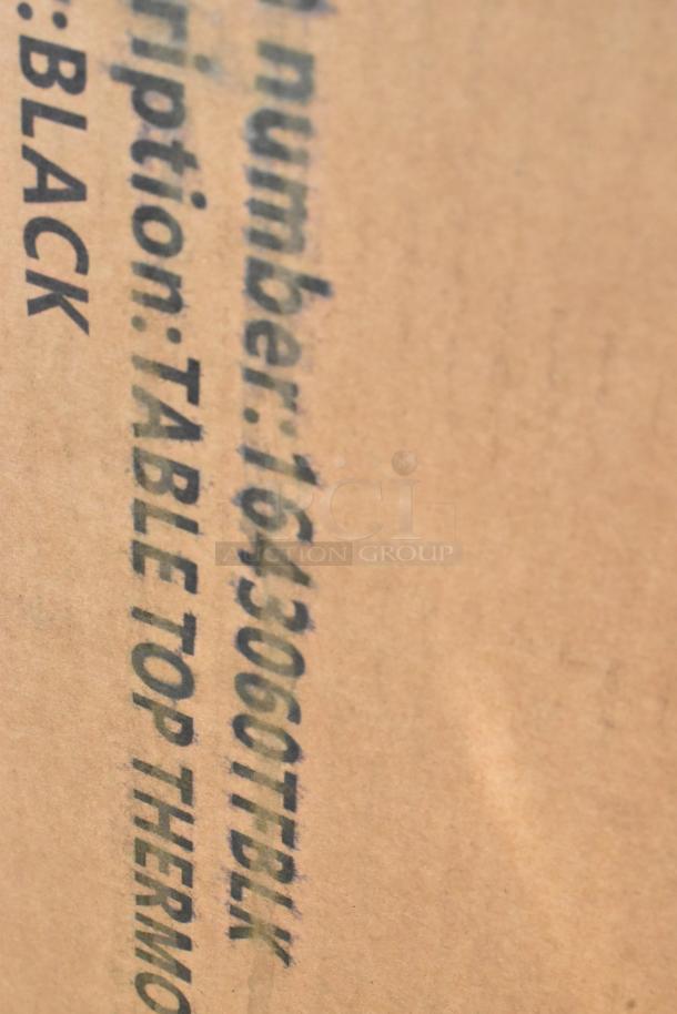 Cardboard box with text "Table Top Thermo, Black" indicating item description and color, likely part of a new auction lot.