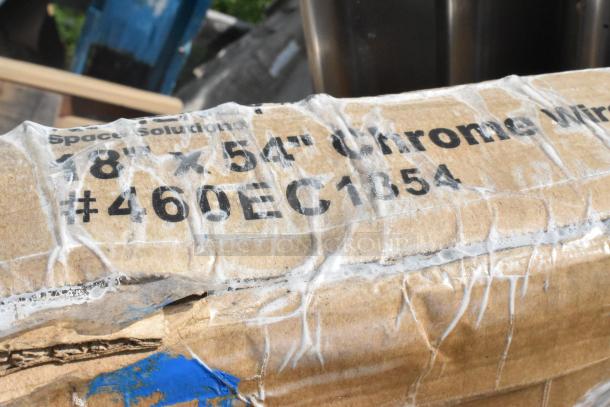 Cardboard box with text "18 x 54 Chrome Wire #460EC1054", indicating new chrome wire shelving item inside.