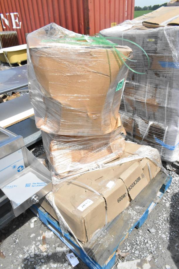 Three brand new scratch and dent items on a pallet, including a stainless table and table base columns, wrapped in plastic.