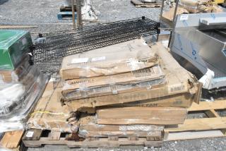 Stack of 10 new scratch and dent items, including folding table and fan, in damaged boxes with visible labels on wooden pallets.