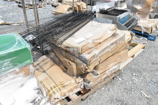 Boxes of new items including a fan and stainless table, marked "Quantity: 1", on pallets, some boxes dented.