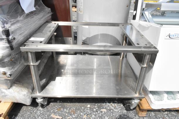 Stainless steel equipment stand with under shelf, commercial casters, used condition, ideal for kitchen storage.
