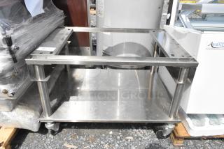 Stainless steel equipment stand with under shelf, commercial casters, used condition, ideal for kitchen storage.