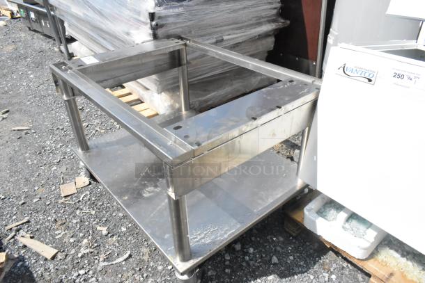 Stainless steel equipment stand with under shelf on commercial casters, showing durable construction and used condition.