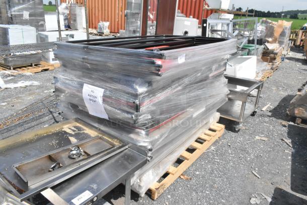 Pallet of round table trolley parts wrapped in plastic film, labeled "PCI Auction Group." Used condition, outdoor setting.