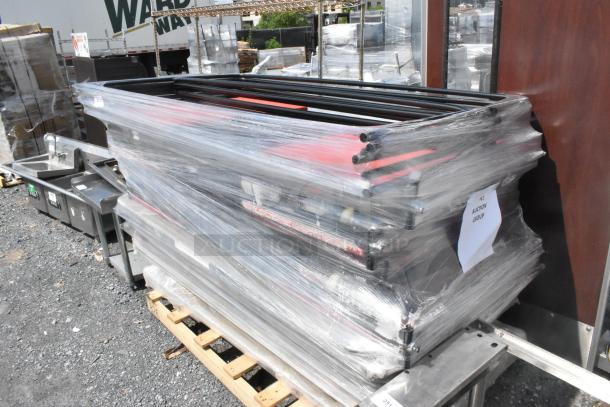 Pallet of round table trolley parts wrapped in plastic, includes rods and brackets. Label: "LOT AUCTION GROUP." Items appear unused.