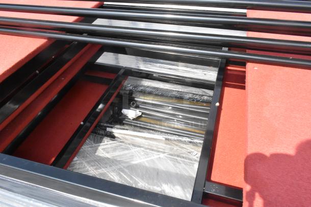 Pallet of round table trolley parts, featuring black metal frames and red surfaces. Parts appear new and wrapped in plastic.