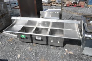 Regency 600S31515215 stainless steel 3-bay sink with dual drain boards, no legs, labeled "Wash" and "Rinse."