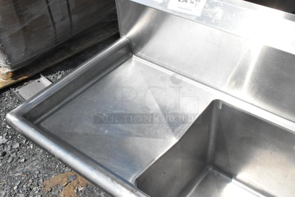 Regency 600S31515215 stainless steel 3-bay sink with dual drain boards, no legs, visible surface wear.