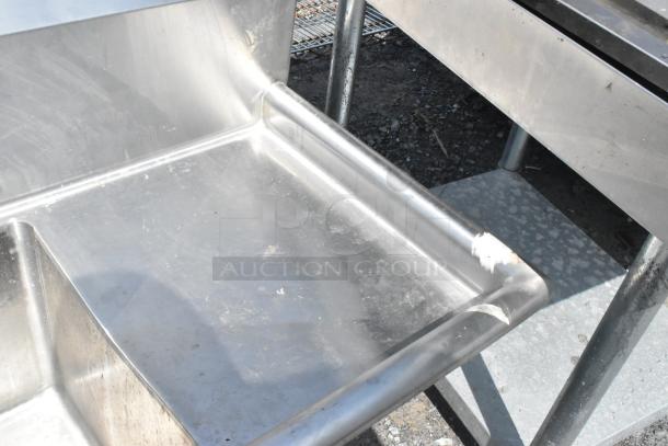 Regency 600S31515215 stainless steel 3-bay sink with dual drain boards, no legs. Some surface wear visible.