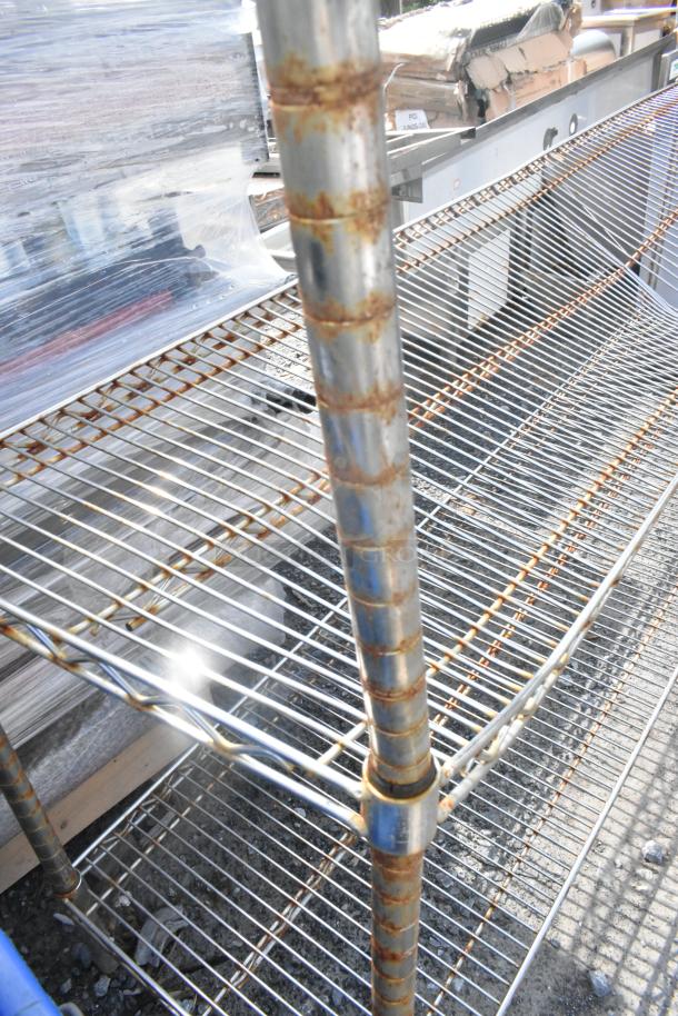 Chrome finish 4-tier wire shelving unit with rust spots, buyer must dismantle. Consider freight charges.