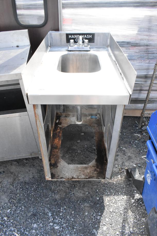 Stainless steel single bay sink with faucet and handles, labeled "HAND WASH ONLY", visible rust and wear on base.