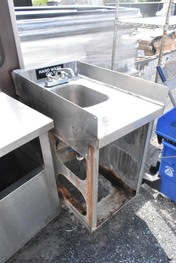 Stainless steel single bay sink with faucet and handles, visible rust on lower frame, "Hand Wash Only" label above sink.