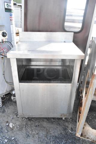 Stainless steel table with open storage compartment, industrial design, used condition, minor surface wear visible.