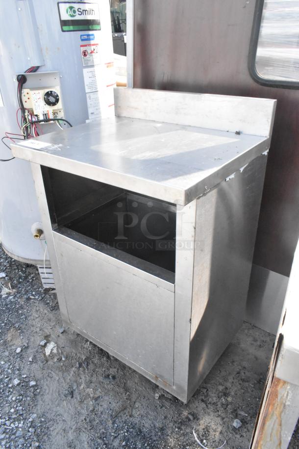 Stainless steel table with storage space, showing minor wear. Durable surface, ideal for kitchen or industrial use.