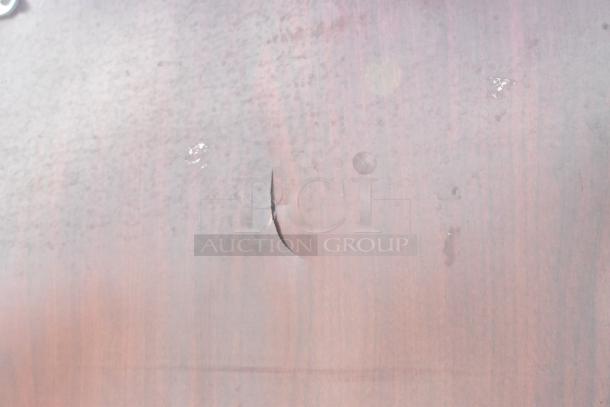 Swinging kitchen door with visible scratch and surface wear, wooden texture, and potential refinishing needs.